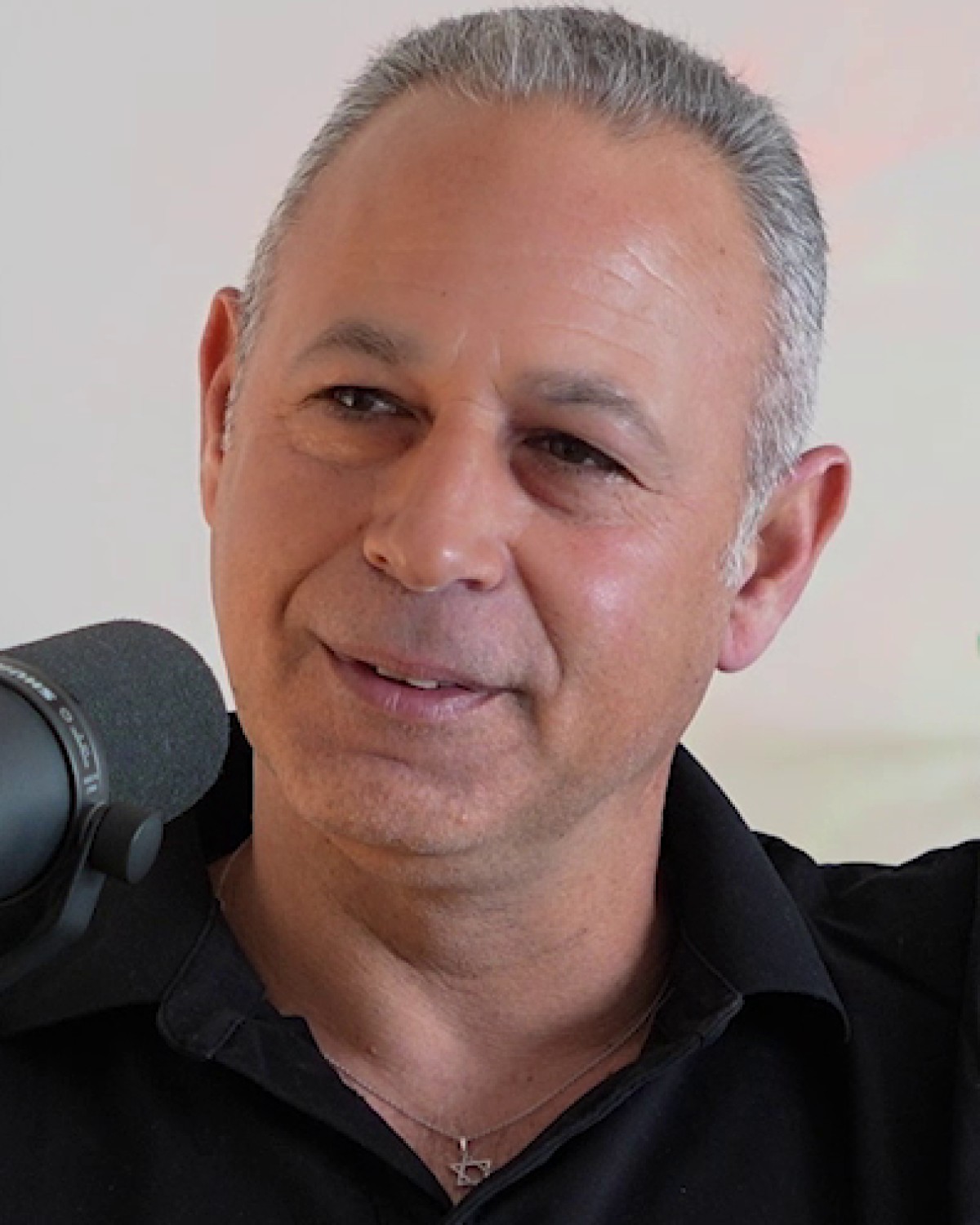 חמיק מזור מדבר מול המיקרופון בהקלטת הפודקאסט