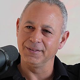 חמיק מזור מדבר מול המיקרופון בהקלטת הפודקאסט